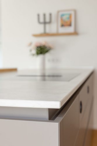 Ein besonderes Detail sind die auf Gehrung gefertigten Formwangen mit umlaufender Griffleiste.